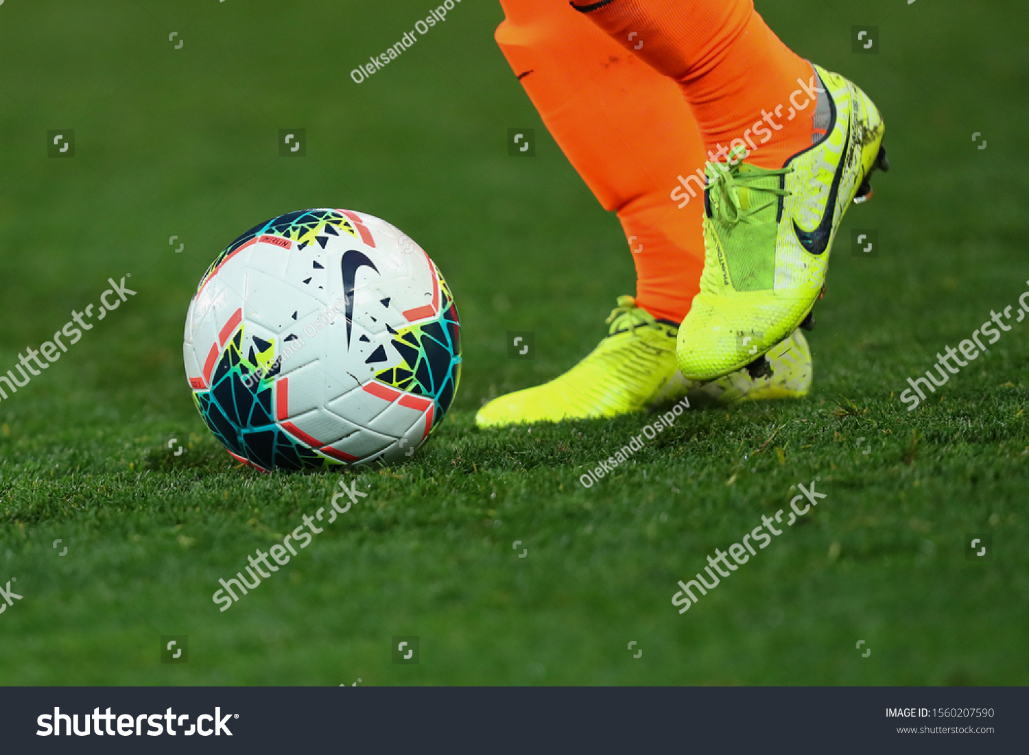 NOVEMBER 10 - KHARKIV, UKRAINE: Nike Merlin 2020 FIFA SOCCER BALL on a grass. Nike football boots. Close-up detailed view. Beautiful green pitch on the background. #1560207590