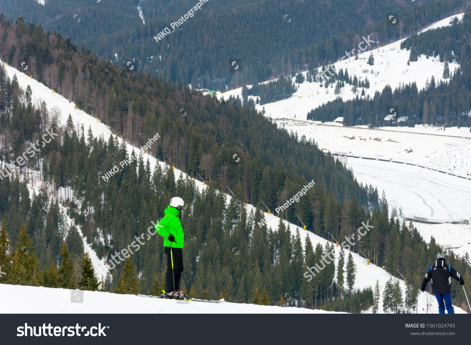 Skiers descend on the slopes of the Carpathian slopes and mountains, on the background are picturesque scenery and ski slopes. #1561024745