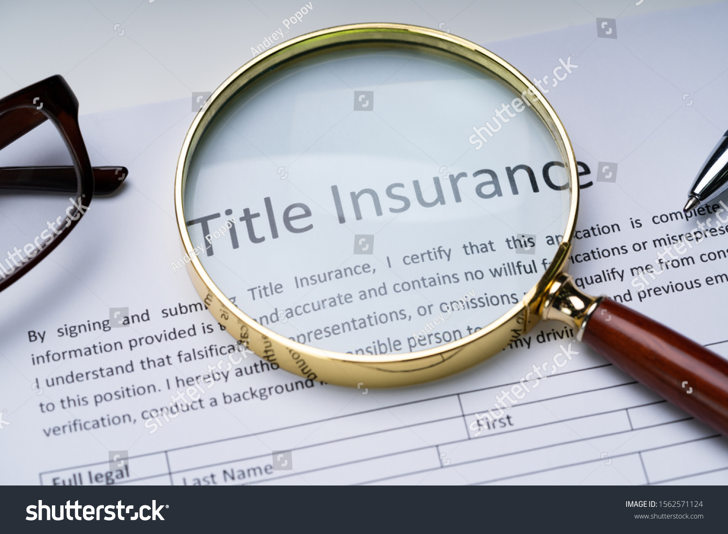 Magnifying Glass Over Title Insurance Form On Table #1562571124