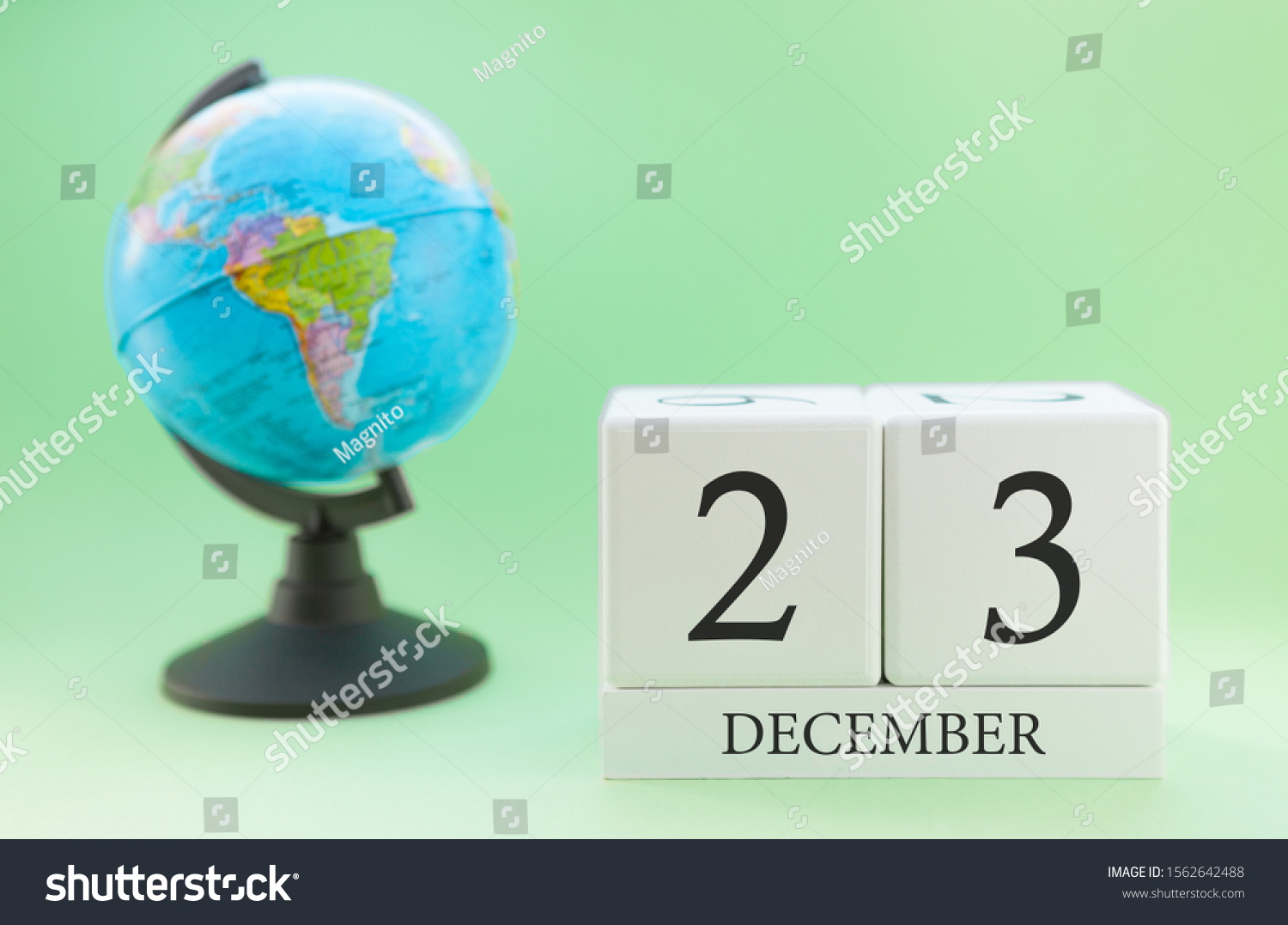 December 23. December month. White cube with numbers and globe on a blurred green background. The concept of New Year and Christmas holidays. #1562642488