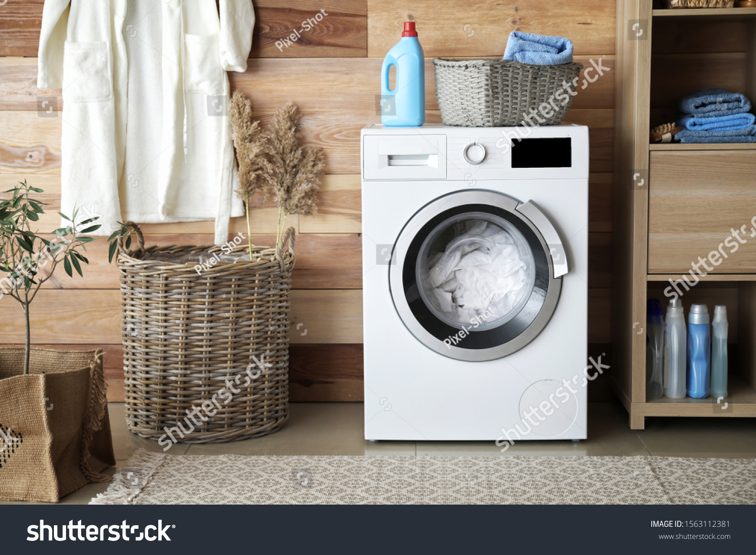 Interior of home laundry room with modern washing machine #1563112381