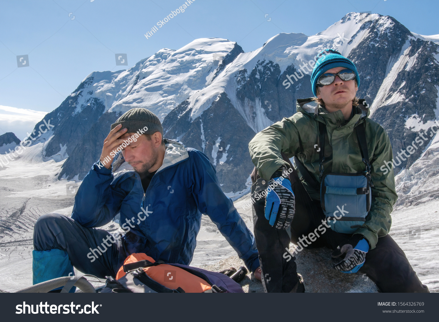 High altitude sickness. Climber holds his head because of headache. #1564326769