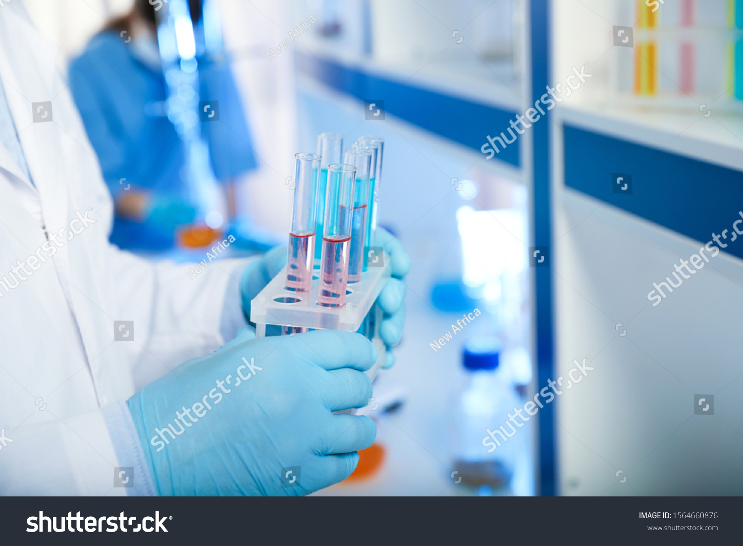 Scientist holding test tubes with liquid indoors, closeup. Laboratory analysis #1564660876