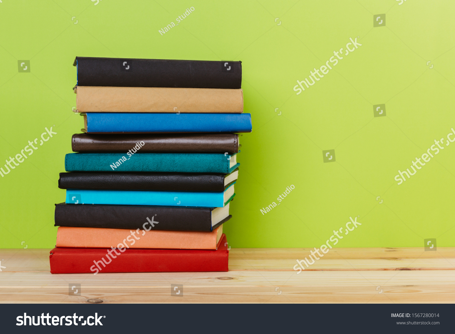 Simple Simple composition of many hardback books, unprocessed books on a wooden table and a green background. back to school. Copy space. Education. #1567280014