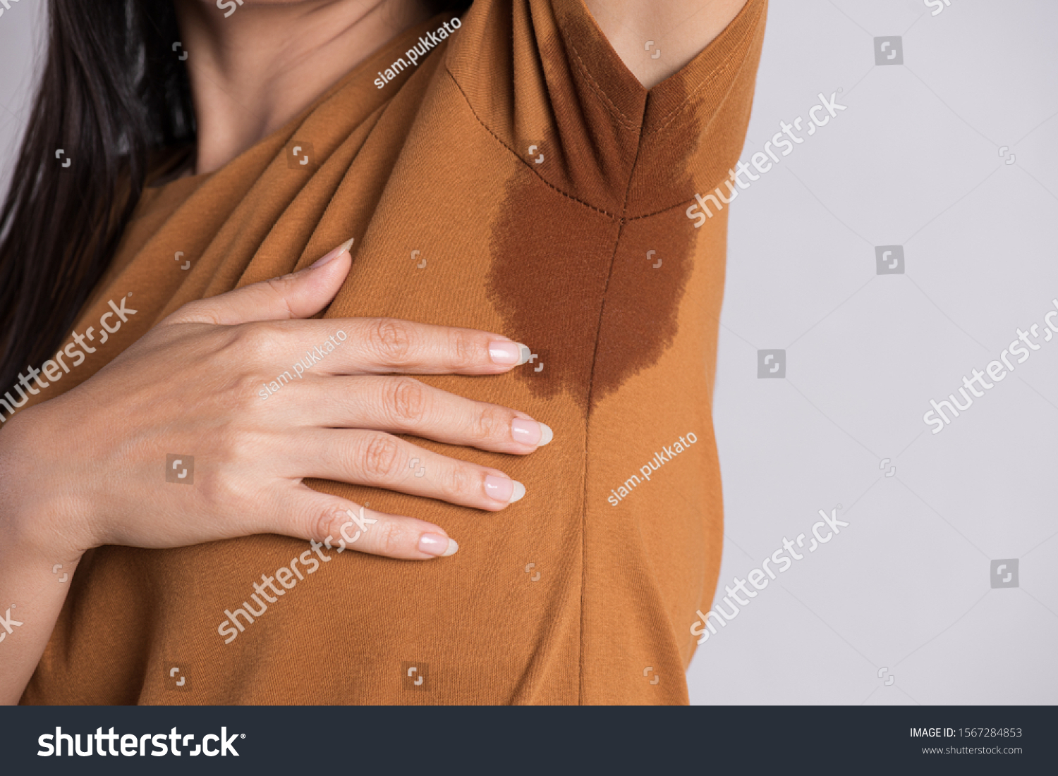 Close-up asian woman with hyperhidrosis sweating. Young asia woman with sweat stain on her clothes against grey background. Healthcare concept. #1567284853