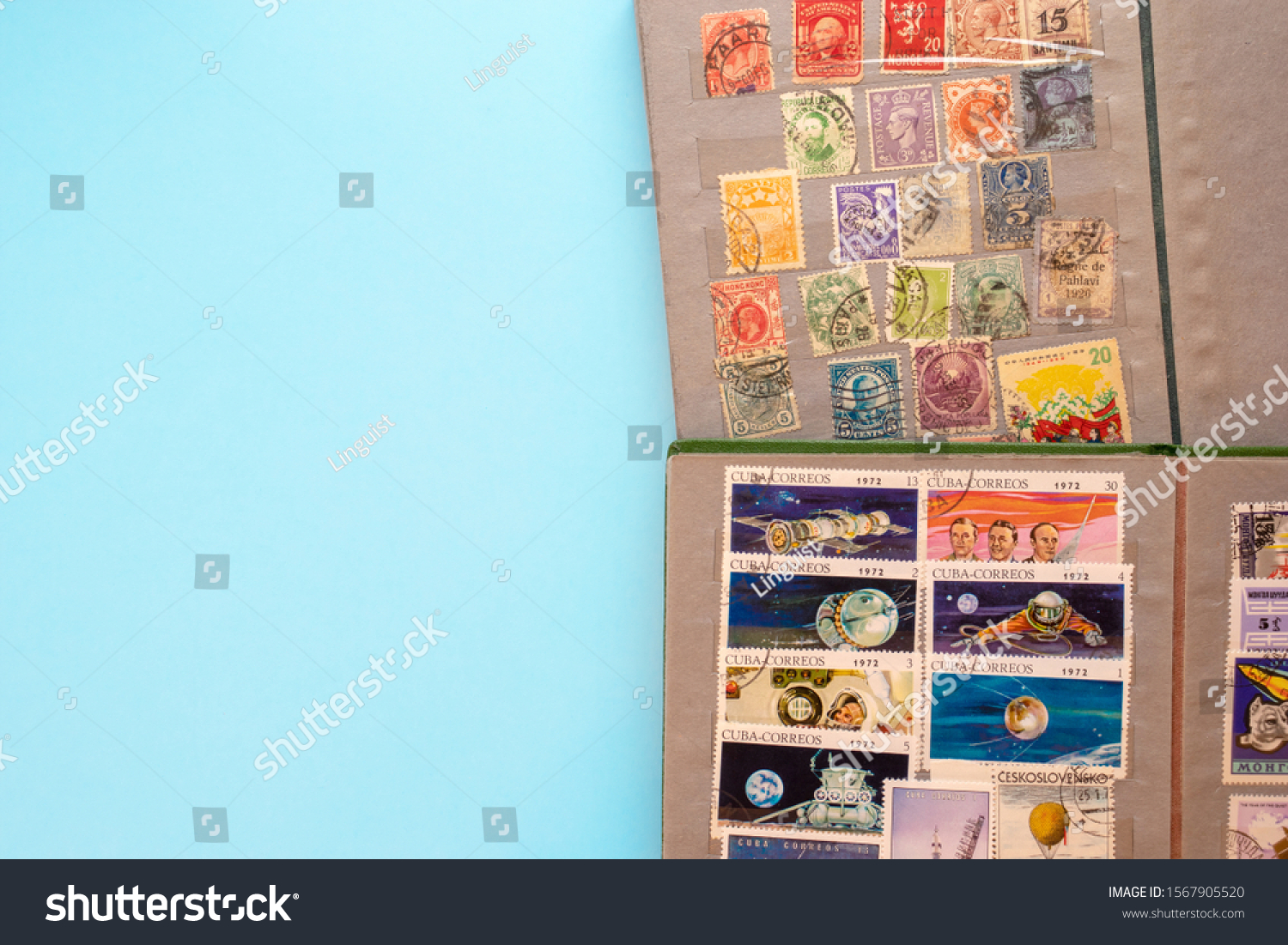 Stamp collecting. Two albums with old expensive valuable post stamps on blue background. #1567905520