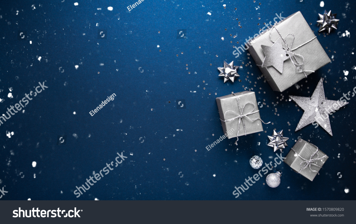 Merry Christmas and Happy Holidays greeting card, frame, banner. New Year. Noel. Silver Christmas gifts, ornaments on blue background top view. Winter holiday xmas theme. Flat lay. #1570809820