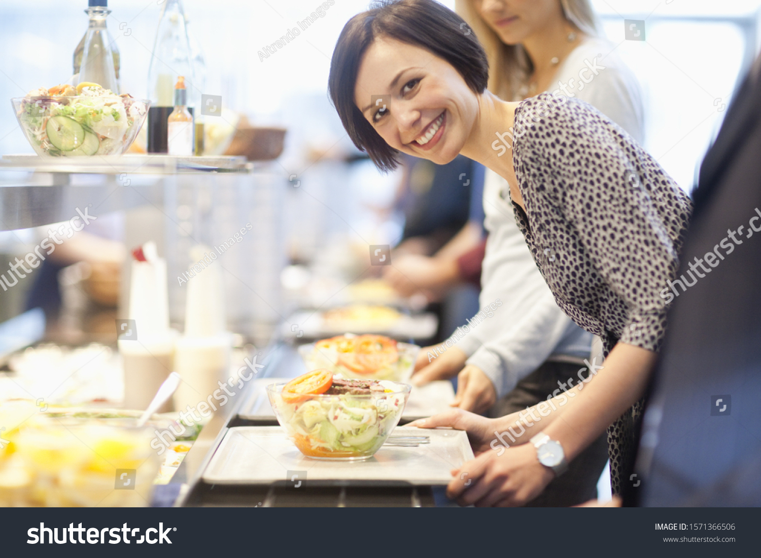 Portrait of businesswoman in lunch line at work cafeteria #1571366506