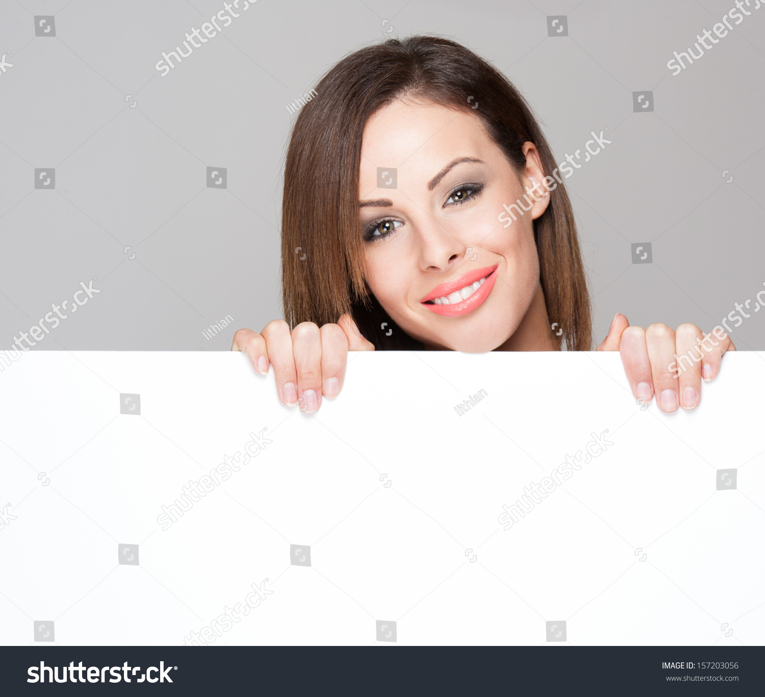 Portrait of a fashionable brunette beauty with blank white billboard for text. #157203056