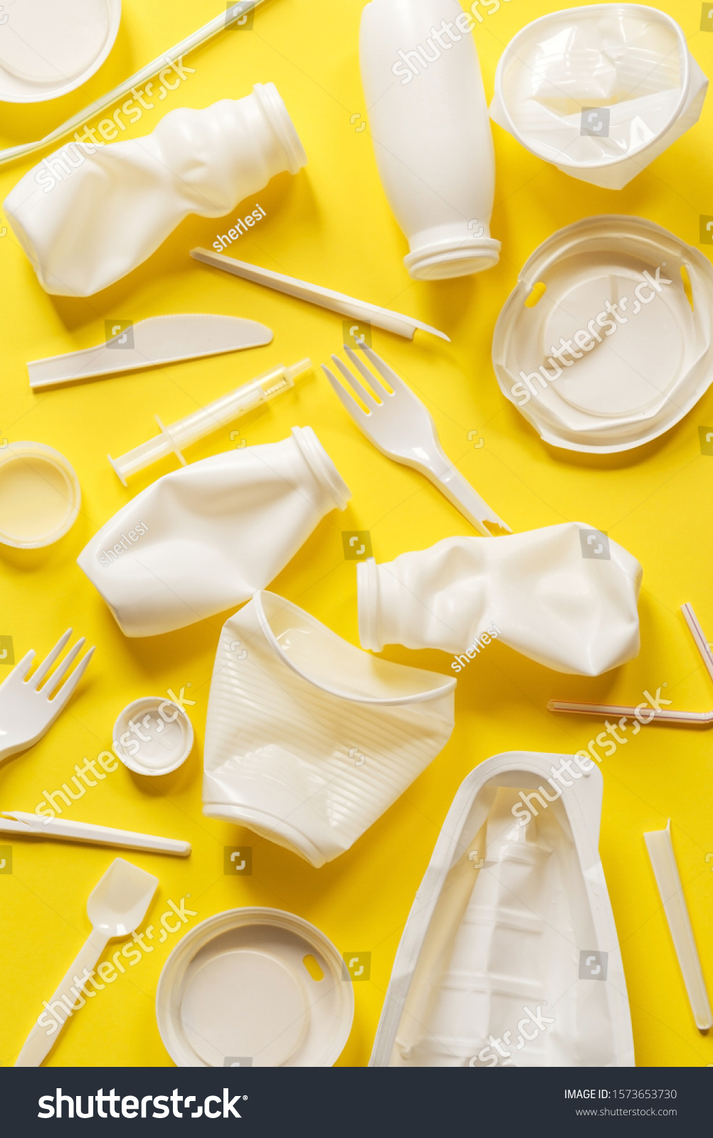 Used white plastic packaging for food on a yellow background. The concept of protecting the environment from plastic waste contamination. Flat lay #1573653730