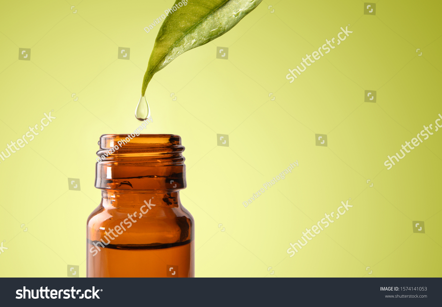 Natural medicine concept with leaf and drop falling into glass jar with medicinal liquid and green gradient background. Horizontal composition. Front view. #1574141053