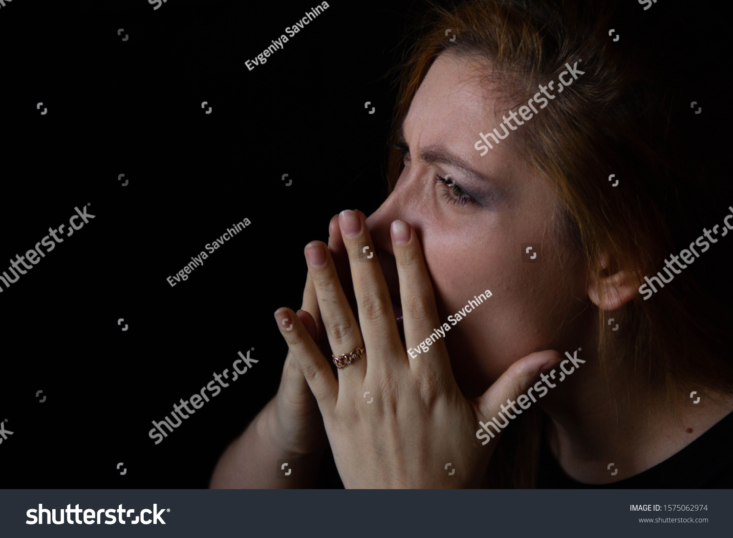 portrait of a young beautiful woman who blows her nose on a black background. #1575062974
