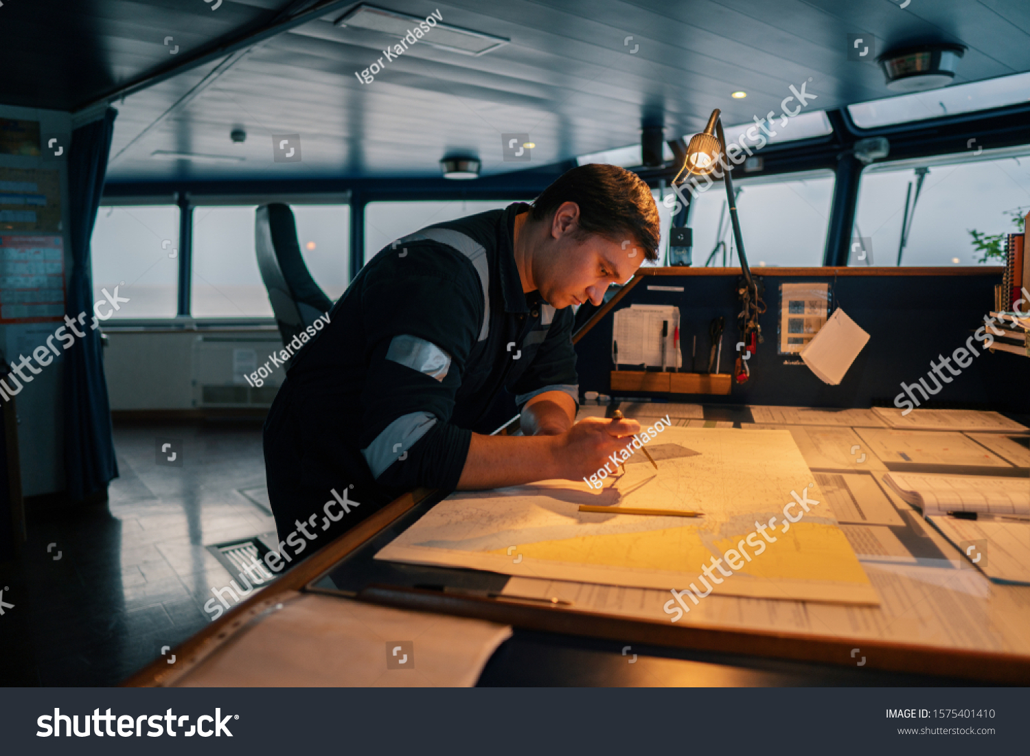 Marine navigational officer during navigational watch on Bridge . He does chart correction of nautical maps and publications. Work at sea #1575401410