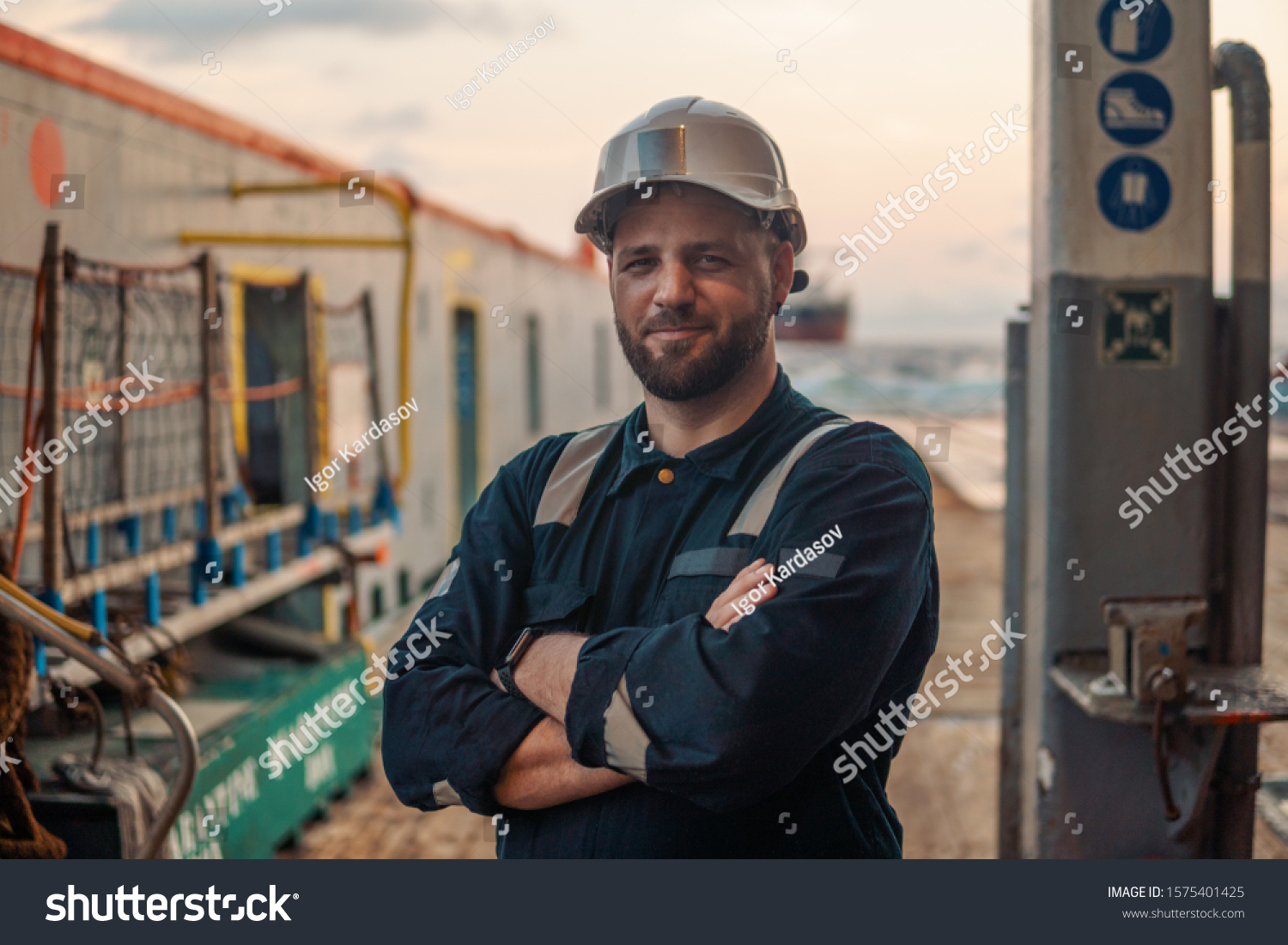 Marine Deck Officer or Chief mate on deck of offshore vessel or ship , wearing PPE personal protective equipment - helmet, coverall #1575401425