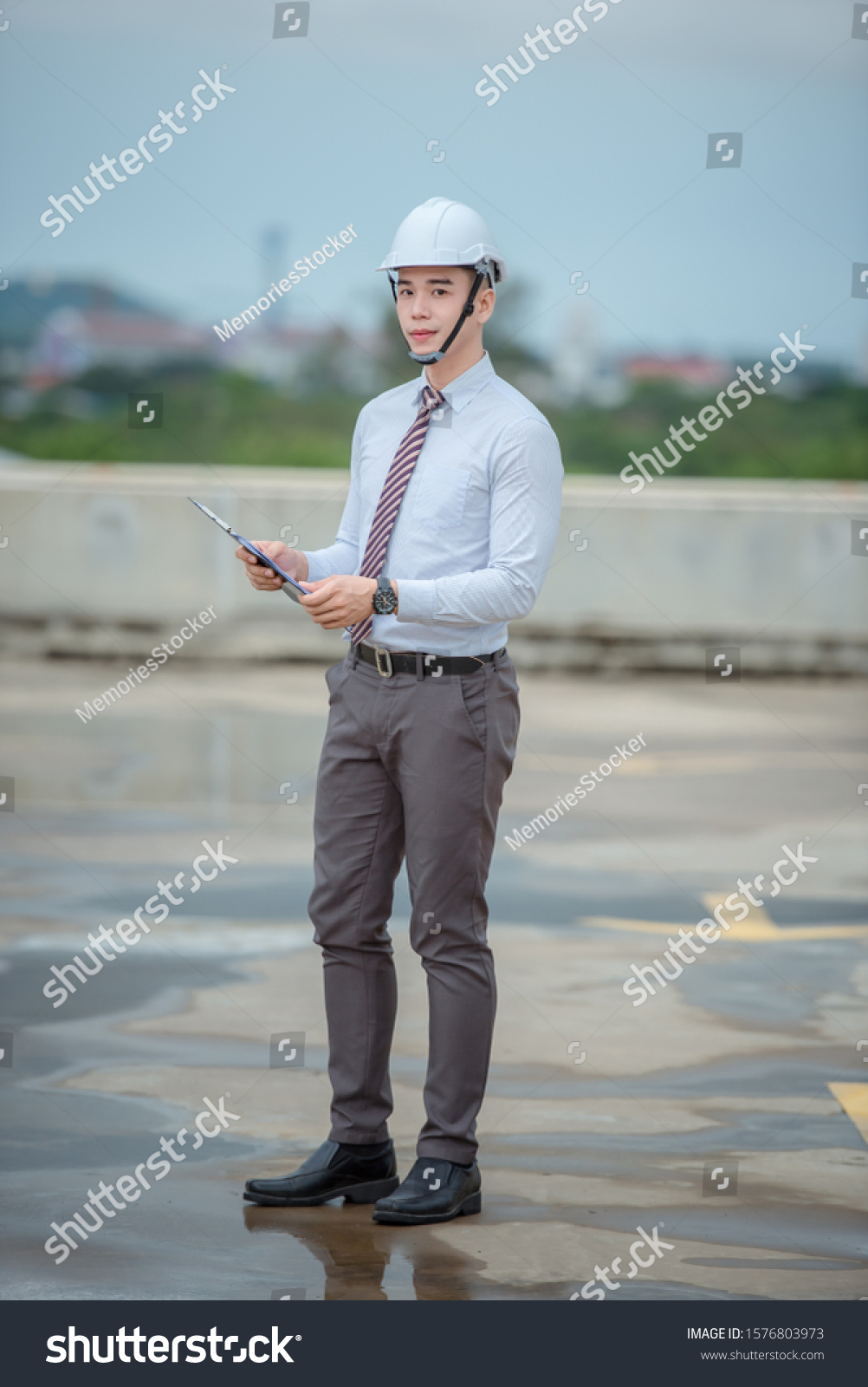 smiling young architect or engineering builder in hard hat with tablet over group of builders at construction site, architect watching some a construction, business, building, industry, people concept #1576803973