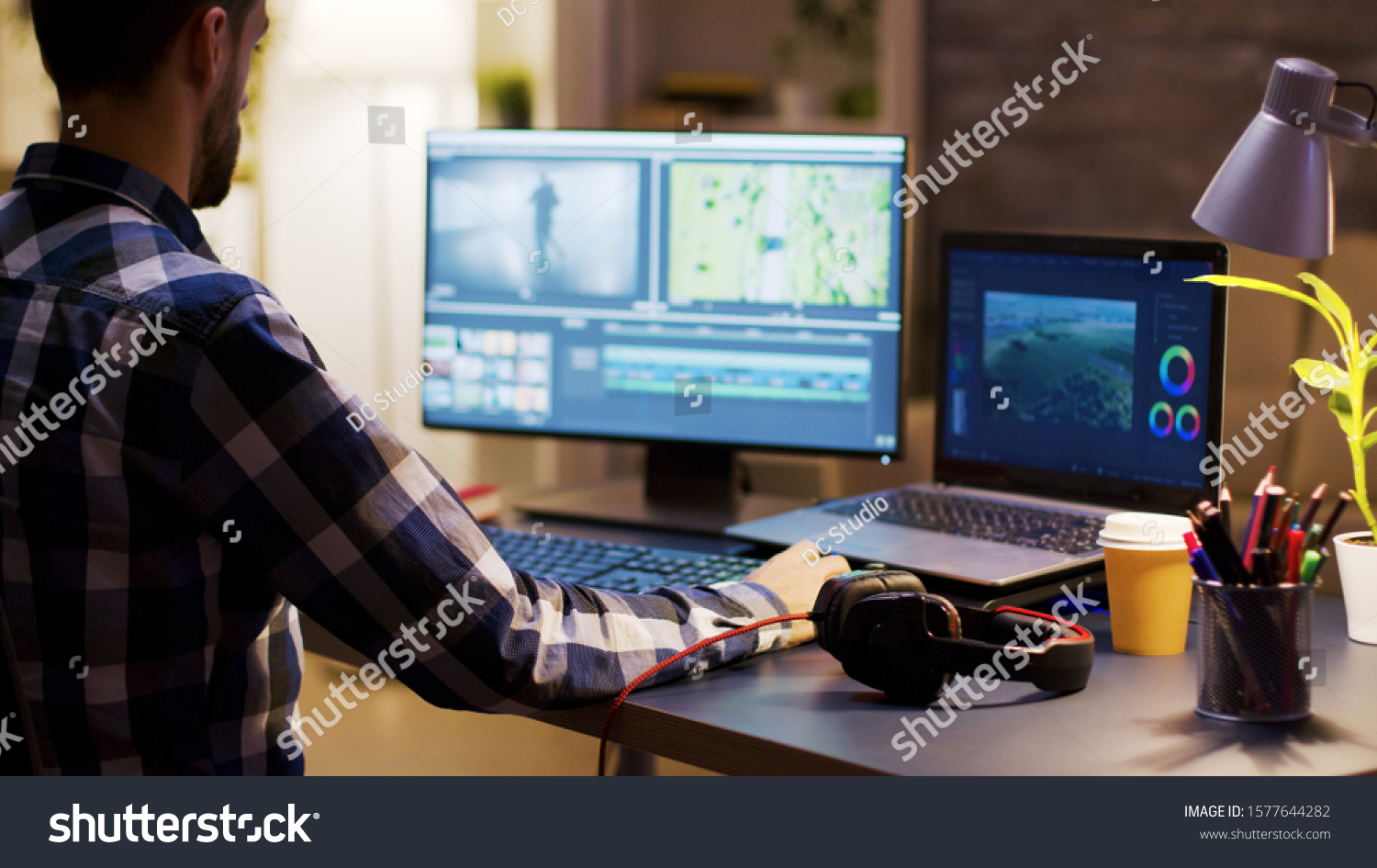 Movie maker editing a film using modern software for post production. Young videographer. Home office. #1577644282