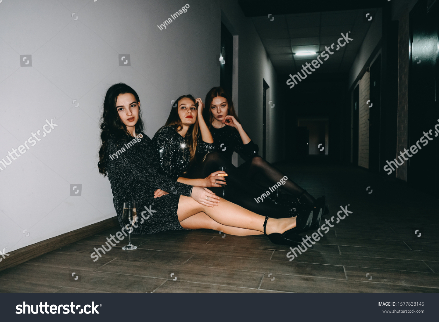 After party, jet set, clubbing, nightlife concept. Tired girls with glasses of champagne sit on the floor after celebrating party.   #1577838145