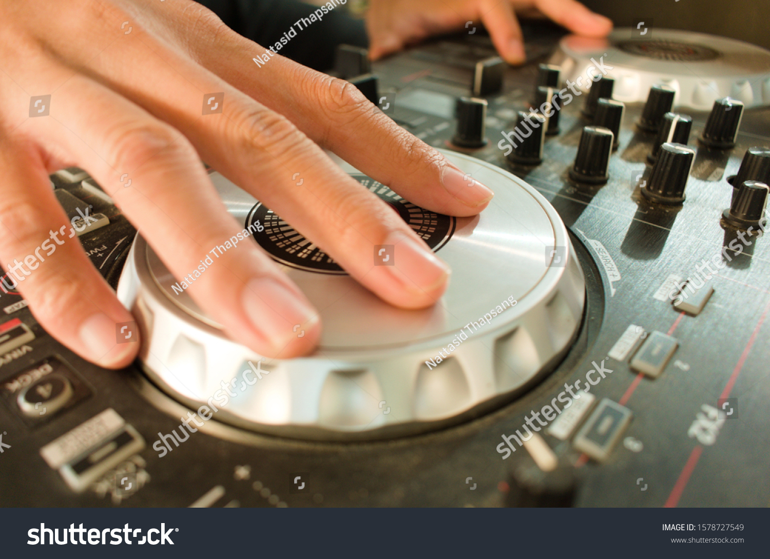 Finger of man that is spinning disc on Pro DJ controller to create music or beat. #1578727549