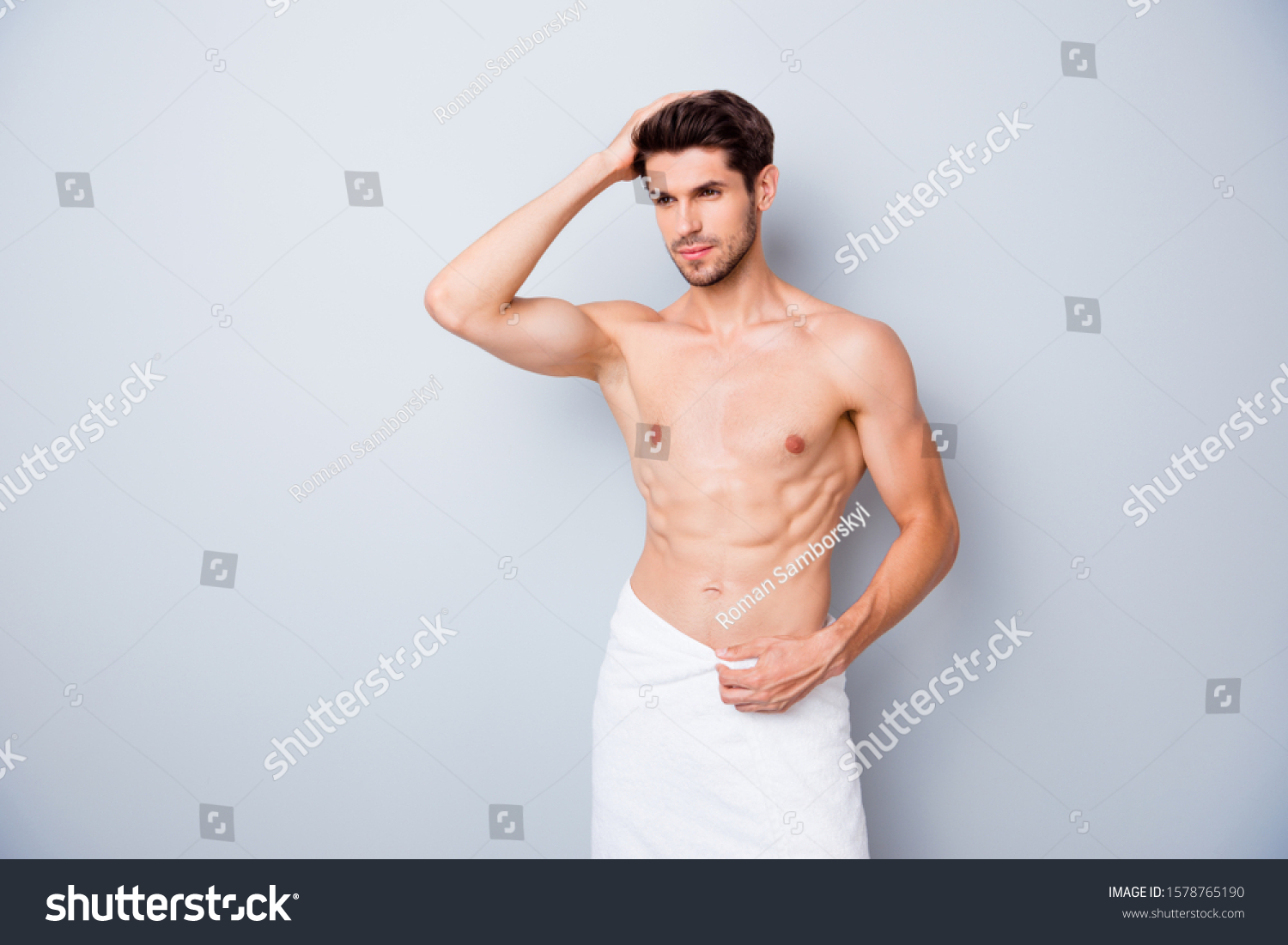Portrait of masculine brutal masculine guy visit barbershop spa salon enjoy anti dander effect touch his shiny effect stand bath with white towel isolated grey color background #1578765190