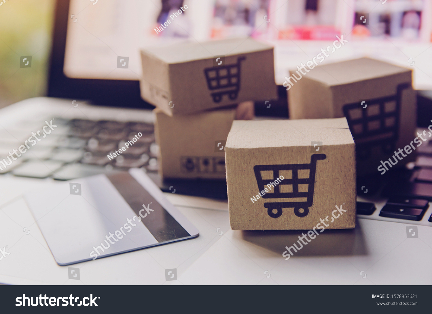 Online shopping - Paper cartons or parcel with a shopping cart logo and credit card on a laptop keyboard. Shopping service on The online web and offers home delivery.
 #1578853621