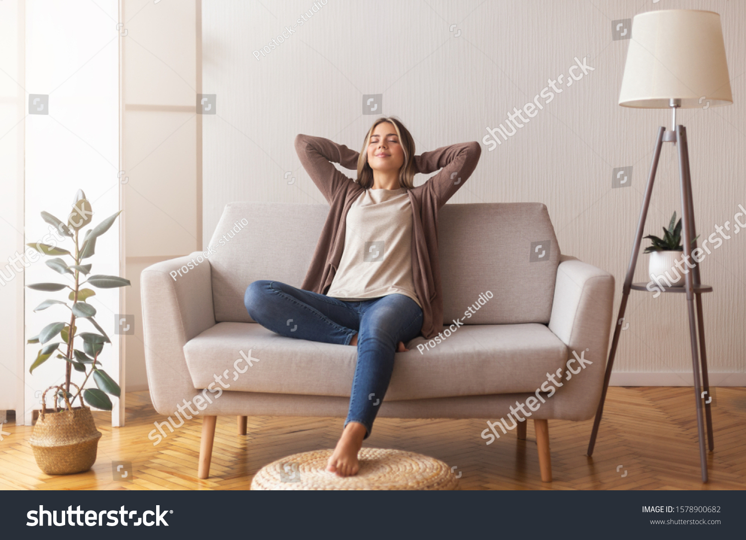 Finally weekends. Millennial girl relaxing at home on couch, enjoying free time, empty space #1578900682