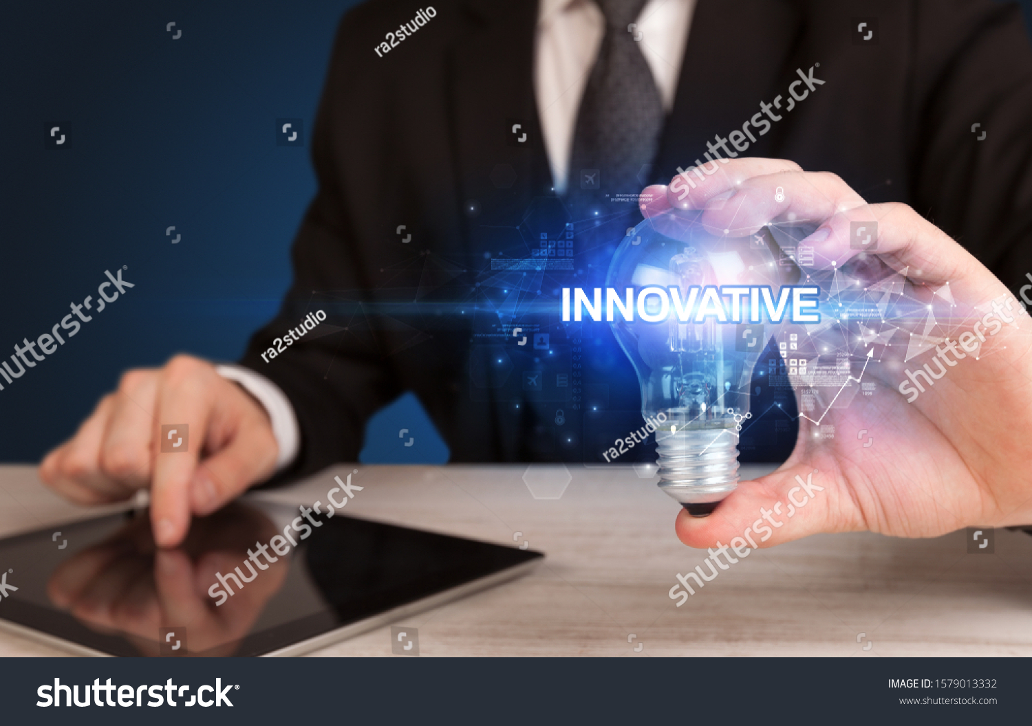 Businessman holding light bulb with INNOVATIVE inscription, innovative technology concept #1579013332