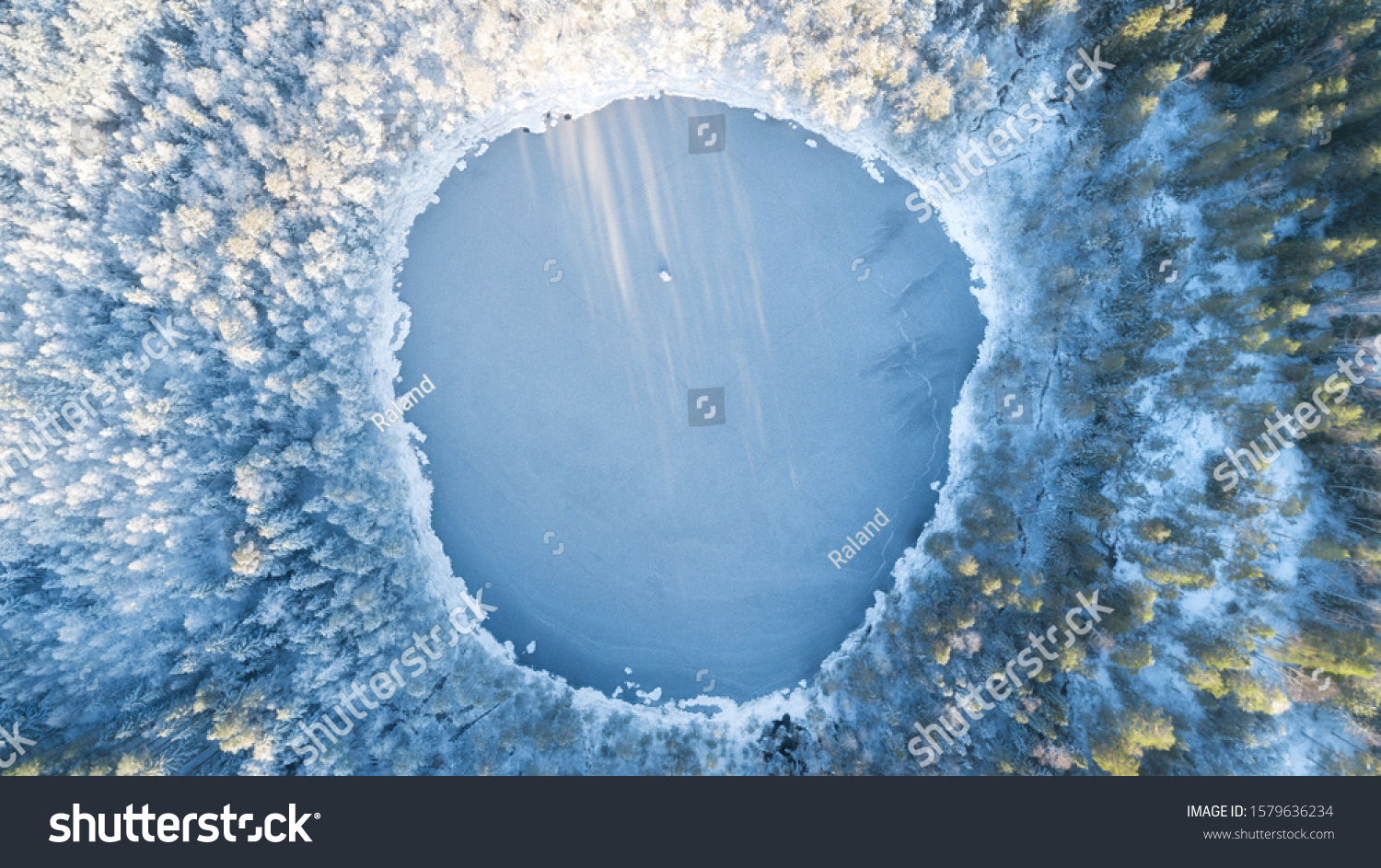 Аerial view of snow covered forest around beautiful lake. Rime ice and hoar frost covering trees. Scenic winter landscape near Helsinki, Finland. #1579636234