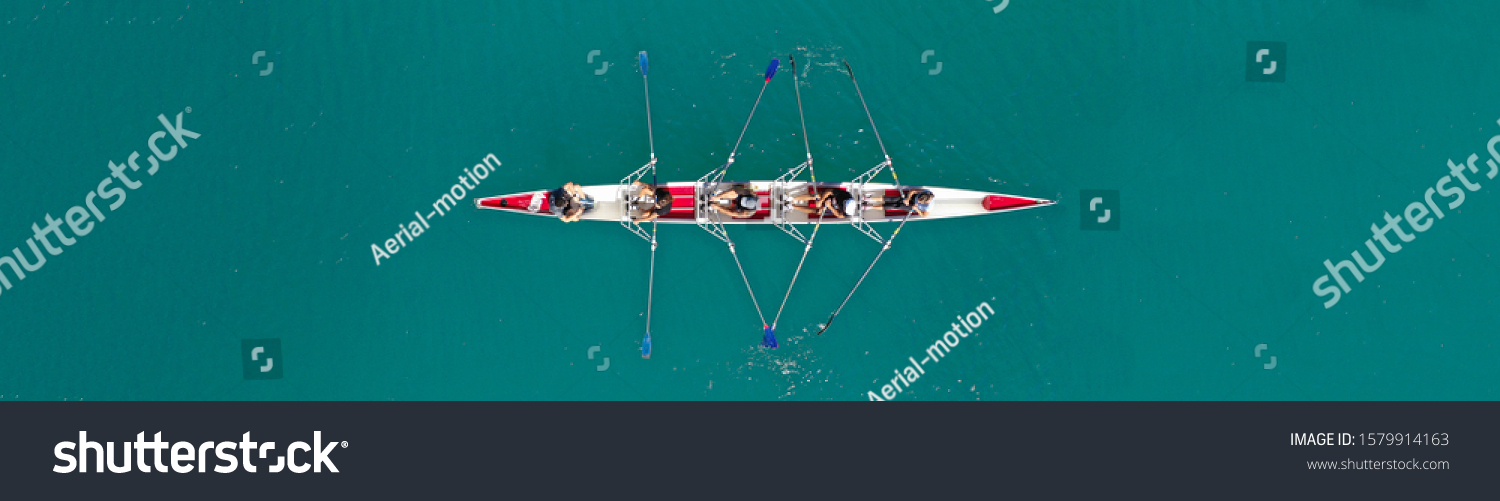 Aerial drone top down ultra wide panoramic view of sport canoe rowing synchronous athletes competing in tropical exotic lake #1579914163