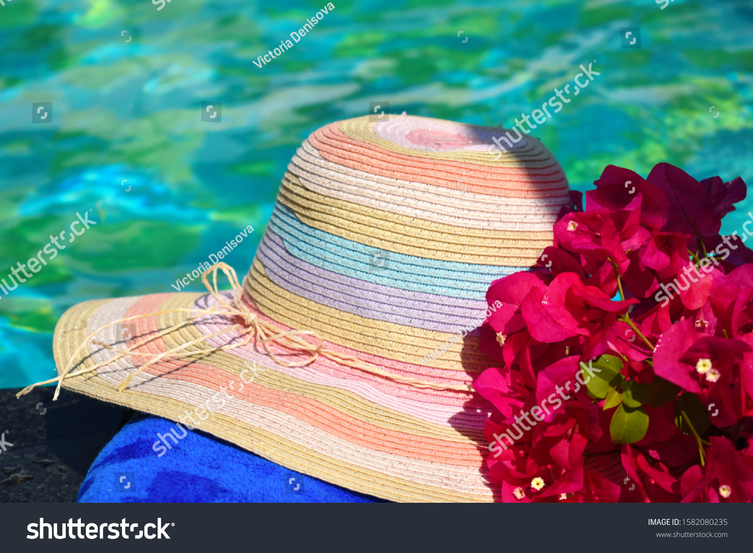 Beautiful hat and flowers at the pool. Sea vacation background. Vacation in the tropics. Holidays in topical countries. #1582080235