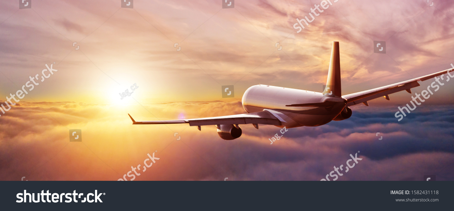 Passengers commercial airplane flying above clouds in sunset light. Concept of fast travel, holidays and business. #1582431118