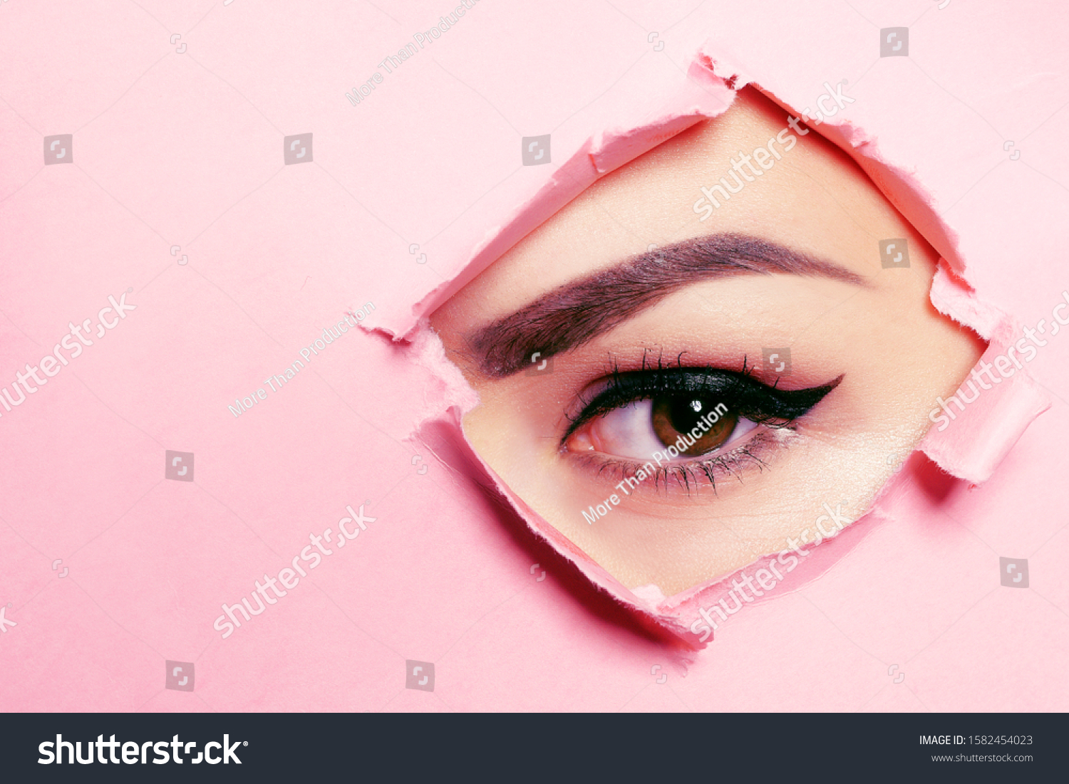 Beautiful brown eye, perfect eyebrows. Beauty salon, eyebrow master, tattoo master shooter and eyebrow. Beautiful eye on a pink background. #1582454023