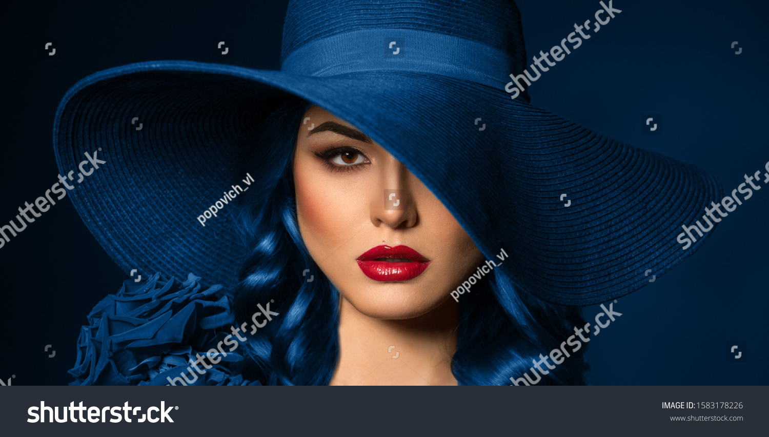 Portrait of a beautiful woman with red lips in a hat, toned in color of the year 2020, classic blue. #1583178226