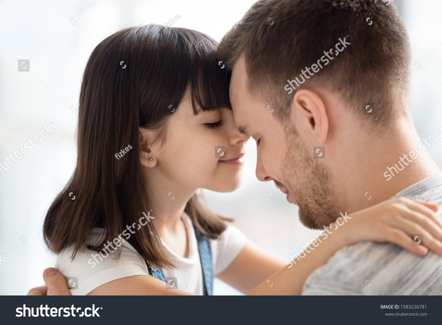 Close up lovely daughter and happy father touching foreheads. Smiling little girl with closed eyes embracing dad expressing love and care. Good family relations concept. #1583226781