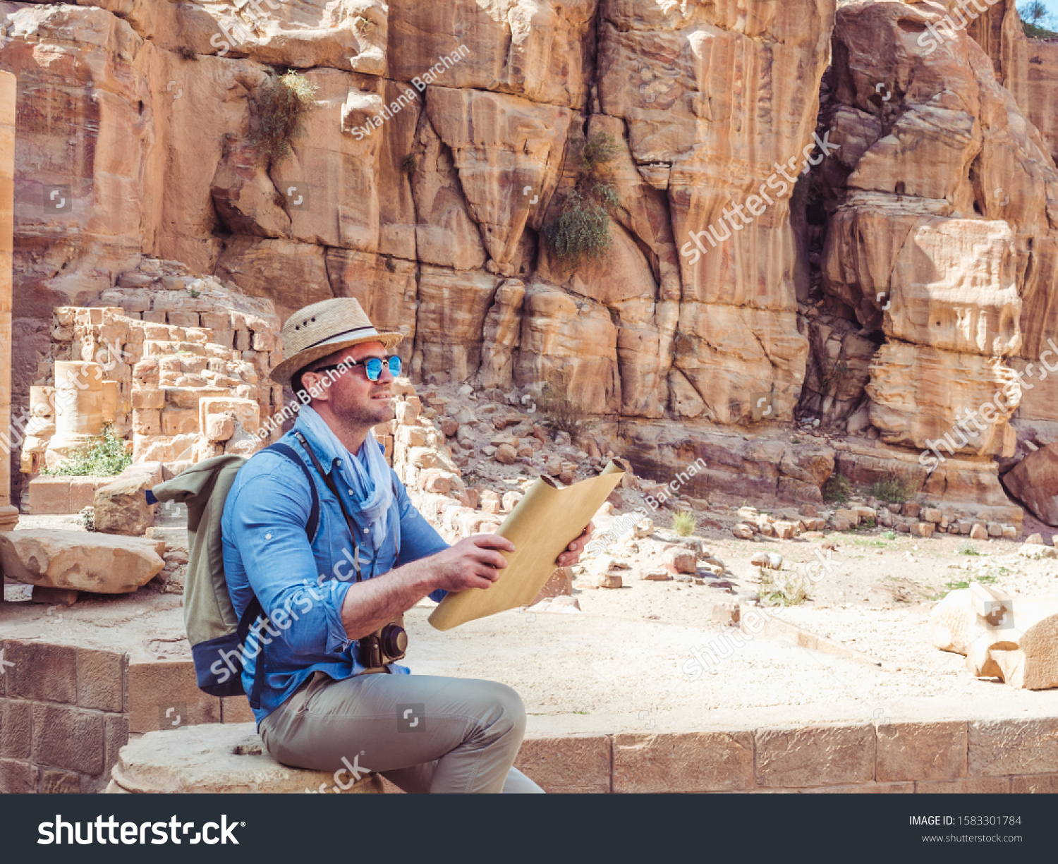 Handsome man, exploring the sights of the ancient, fabulous city of Petra in Jordan. Colorful photos. Concept of leisure, vacation and travel #1583301784