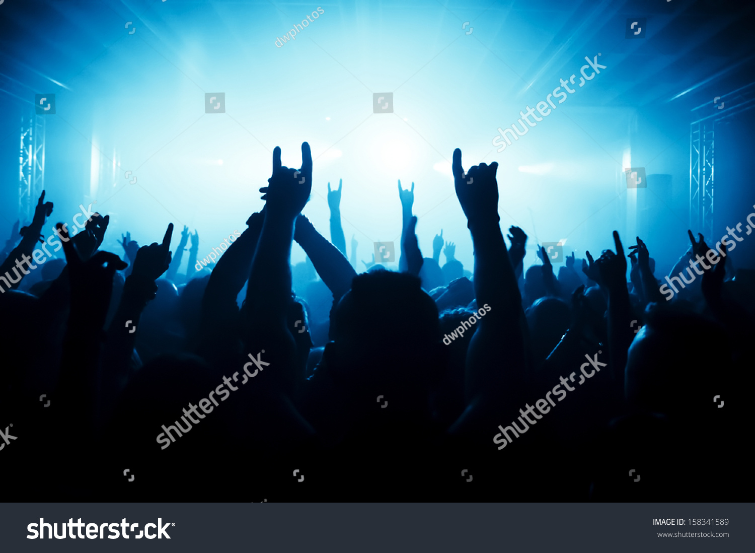 silhouettes of concert crowd in front of bright stage lights #158341589