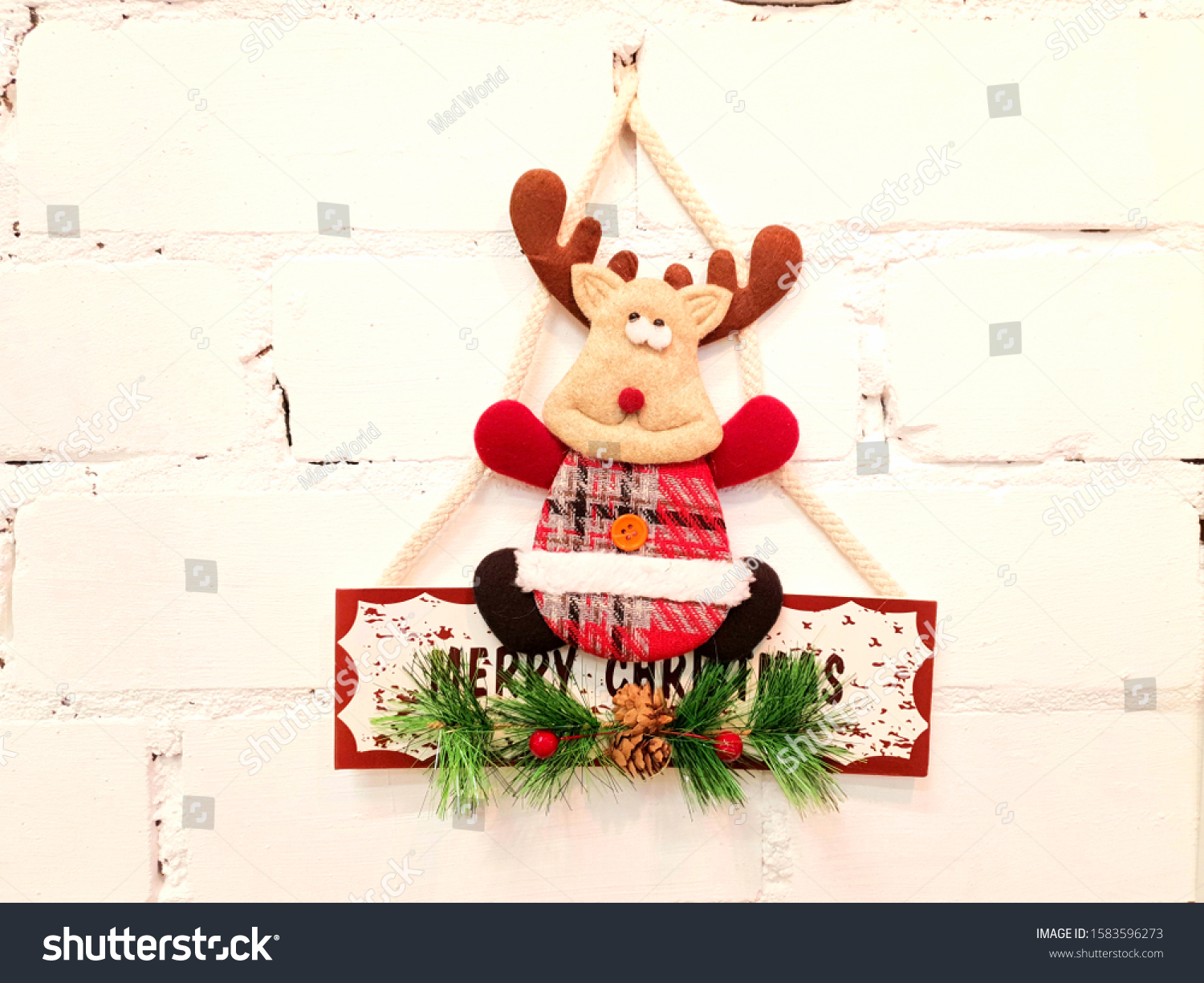 Deer, toys, inscription and Christmas holiday decorations. The decorations are attached to the wall in white and serve as decoration in the interior of the house. #1583596273