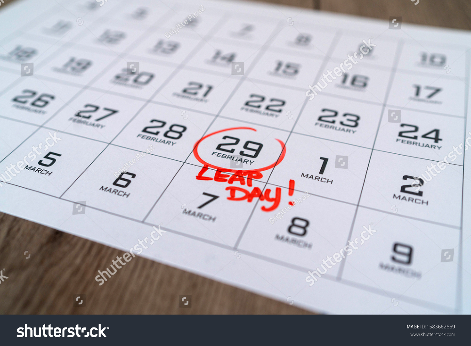 Calendar with marking in red ink of leap day: 29 february. With handwritten text of leap day. Close up with small depth of field. #1583662669
