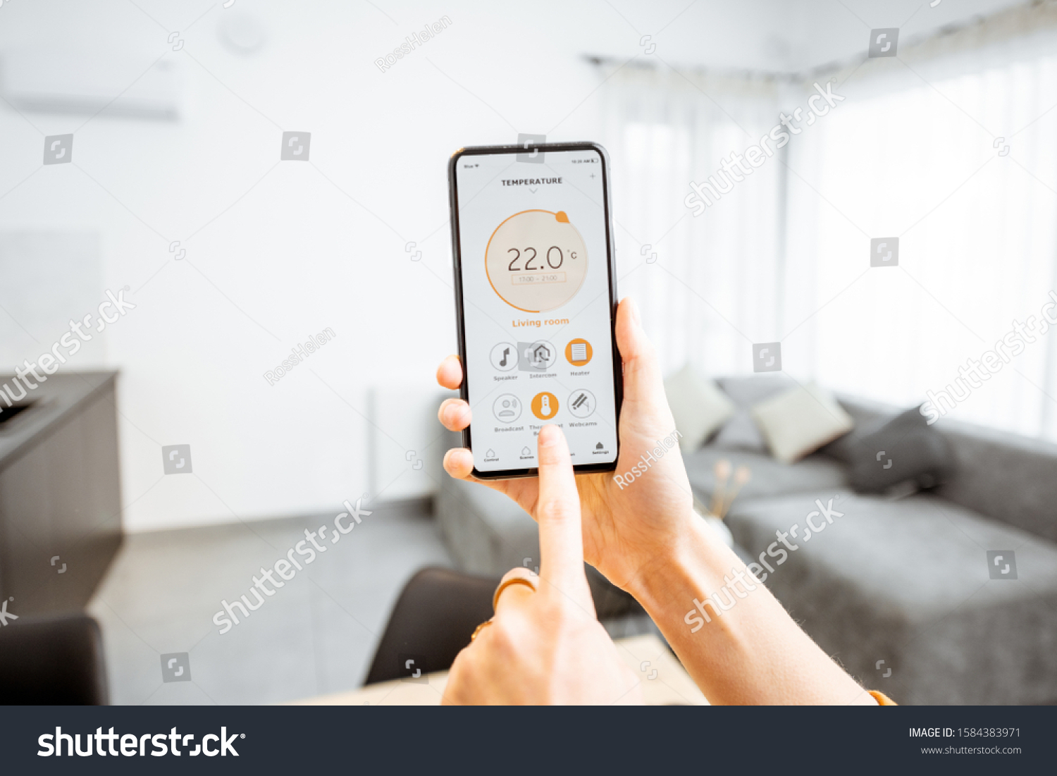 Controlling home heating temperature with a smart home, close-up on phone. Concept of a smart home and mobile application for managing smart devices at home #1584383971