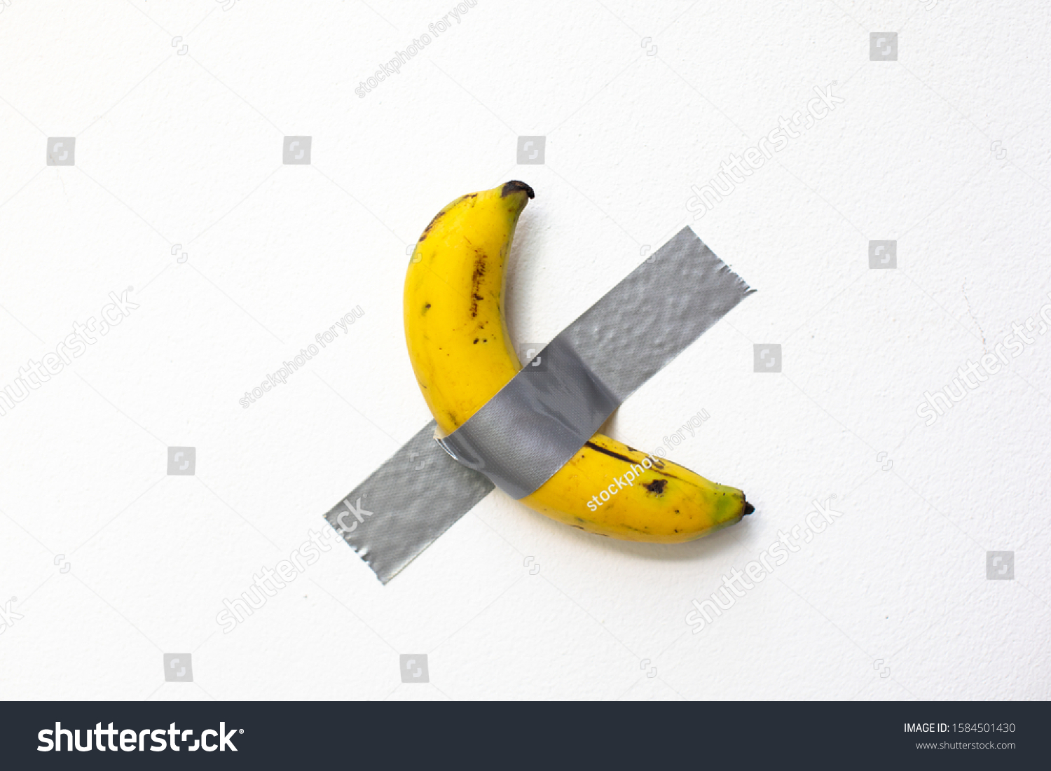 duct taped banana on white wall