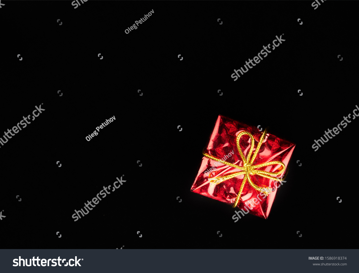 Christmas gift in red paper isolated at black background. Gift box. #1586918374