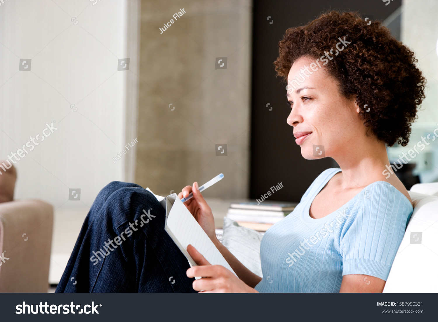 Woman writing a diary or journal, relaxing at home #1587990331