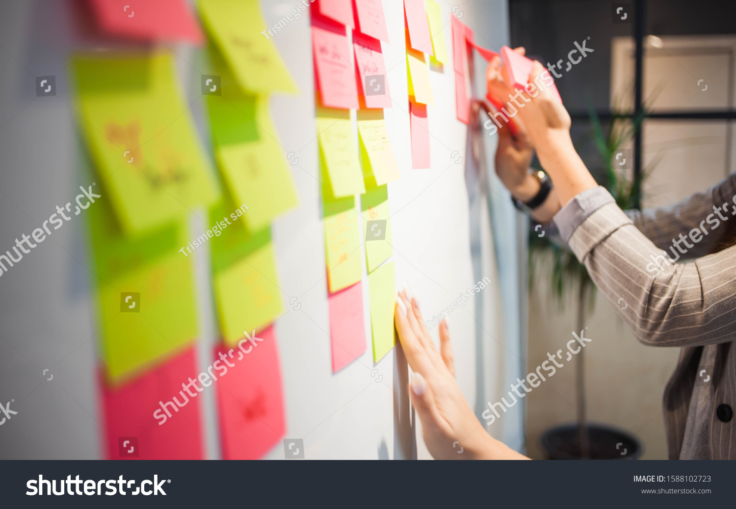 project management, agile methodology. young business woman in the office are planning product development and support. Project manager glue sticky stickers on the Board #1588102723