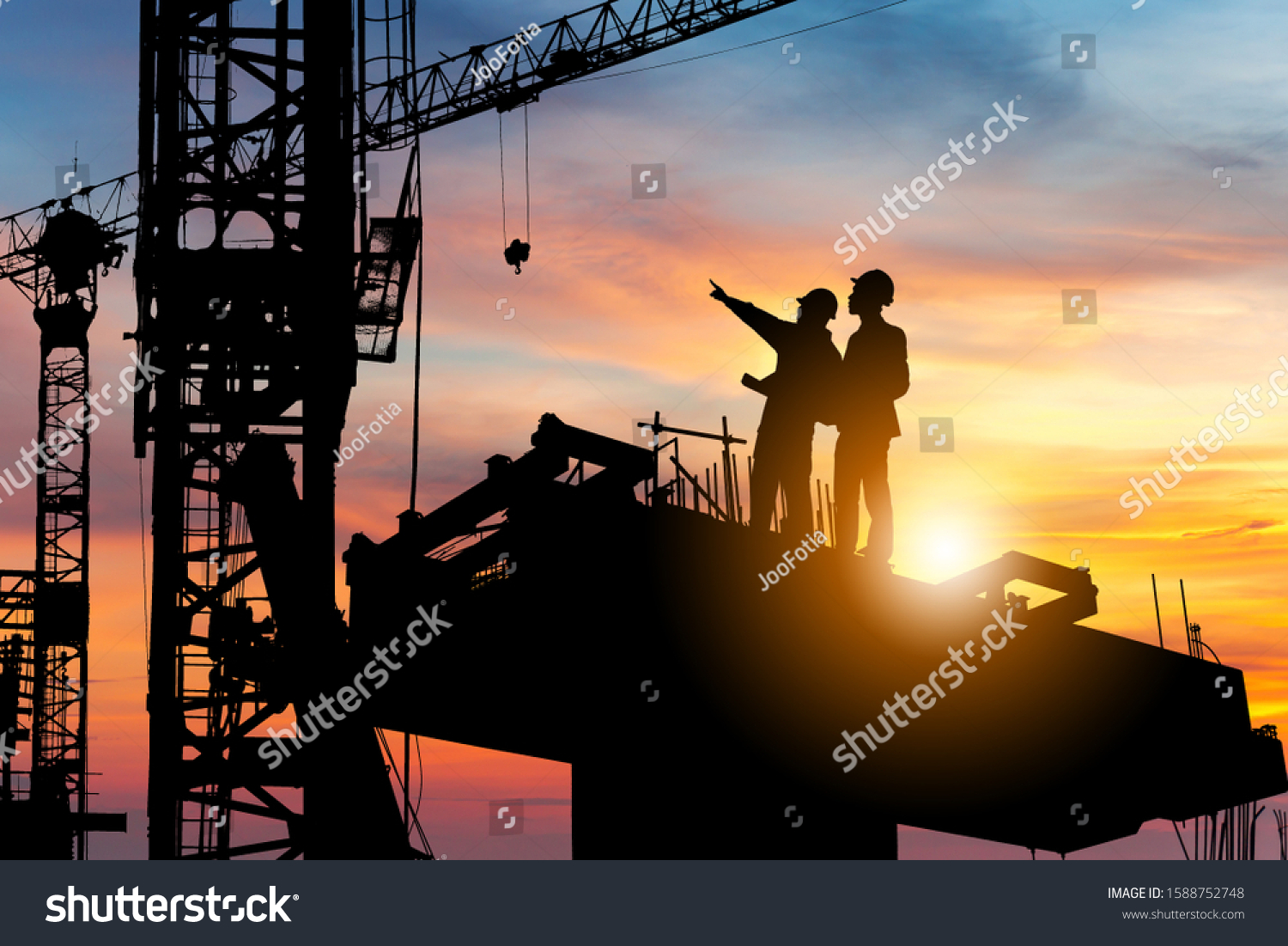 Silhouette of Engineer and worker checking project at building site background, construction site at sunset in evening time. #1588752748