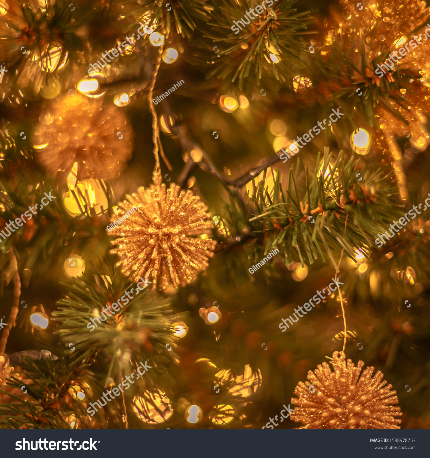 Christmas tree with gold bauble ornaments. Decorated Christmas tree closeup. Balls and illuminated garland with flashlights. New Year baubles macro photo with bokeh. Winter holiday light decoration #1588978753