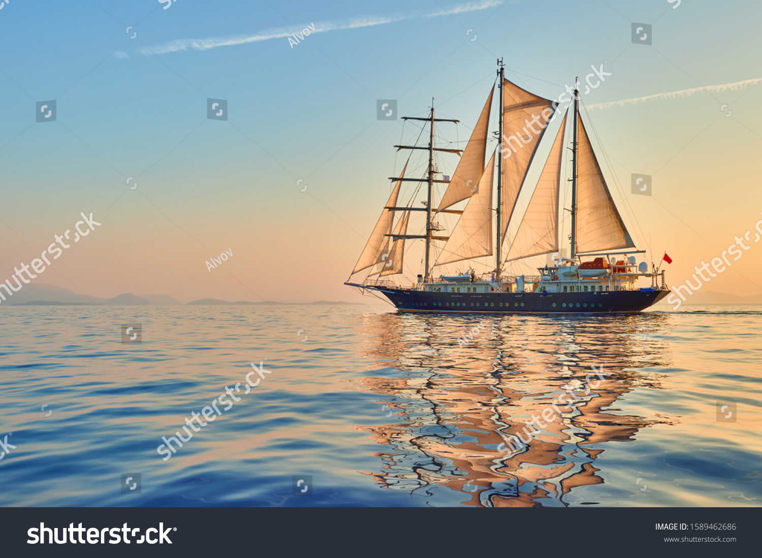 Cruises and yachting. Sailing ship with sails at sunset #1589462686