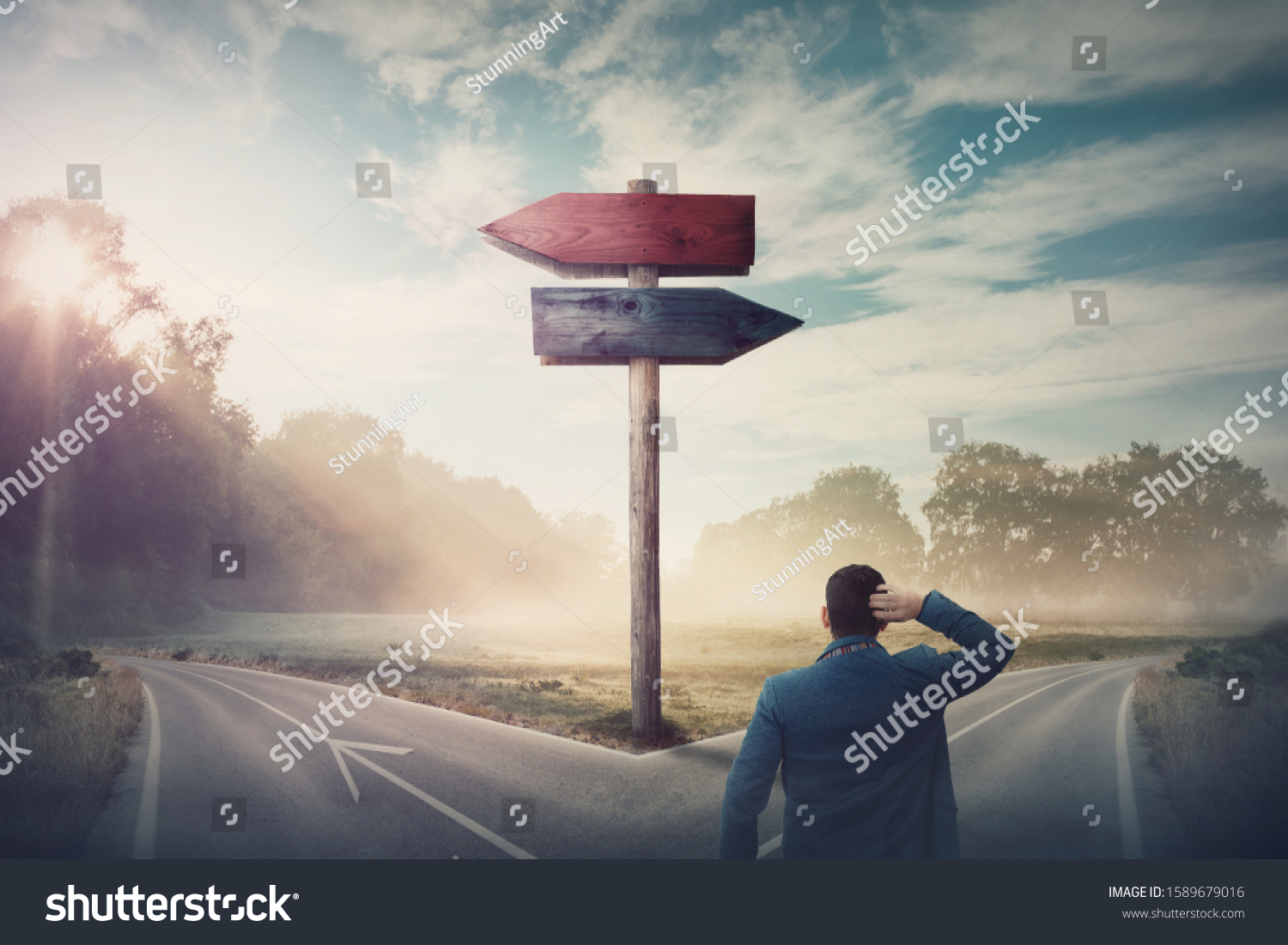 Rear businessman in front of crossroad and signpost arrows shows two different courses, left and right direction to choose. Road splits in distinct direction ways. Difficult decision, choice concept. #1589679016