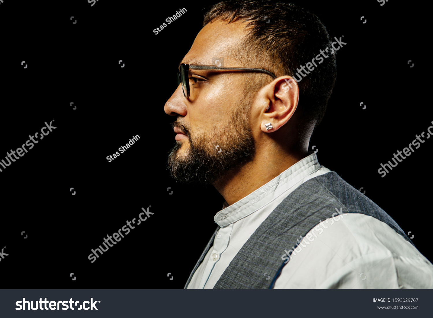 Portrait of Barber in a shirt on the Studio with scissors, bearded Barber on a black background. #1593029767