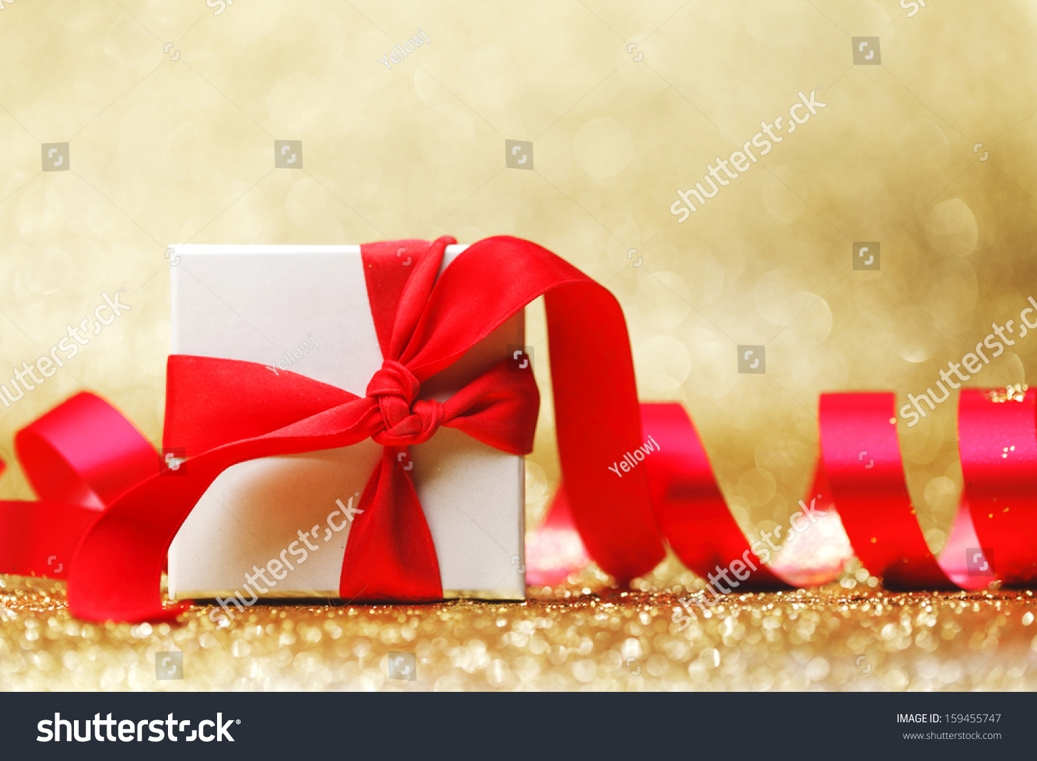 Christmas gift in white box with red ribbon decoration on golden background #159455747