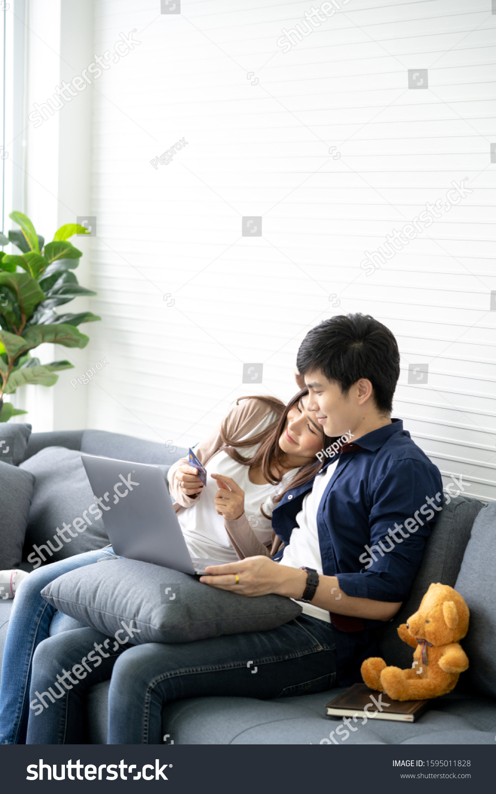 Couple shopping online with credit card and using laptop computer at home. #1595011828
