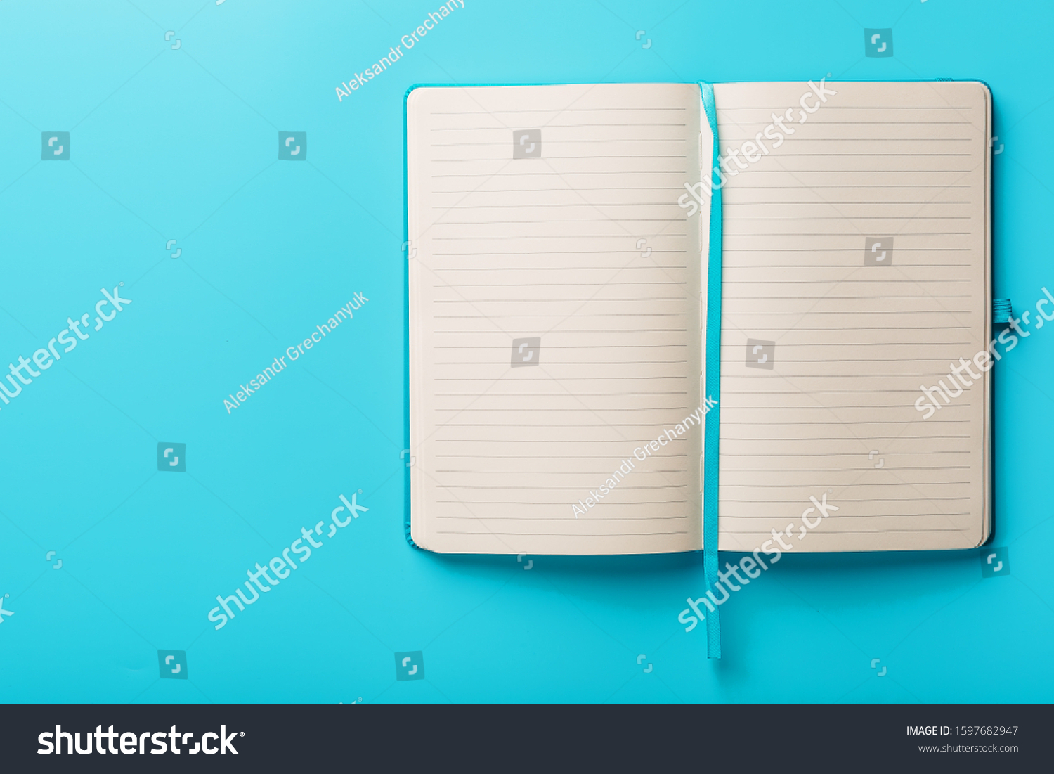 Open notebook, a book with blank and blank pages on a blue background, top view. #1597682947